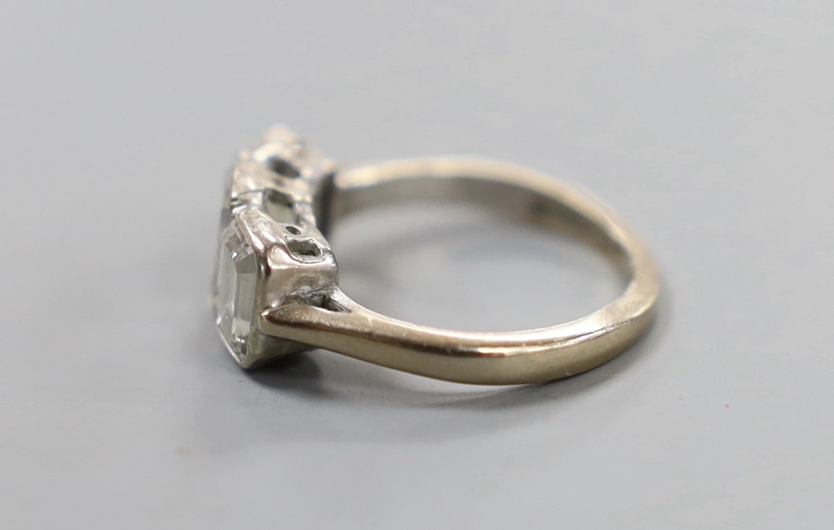 A modern 18ct white gold and two (ex three) stone graduated emerald cut diamond set ring, size G, gross weight 3.3 grams